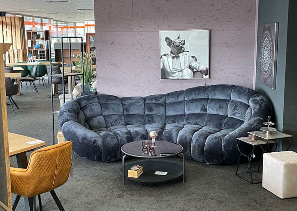 Eine blau-graue Couch steht hinter einem Wohnzimmertisch